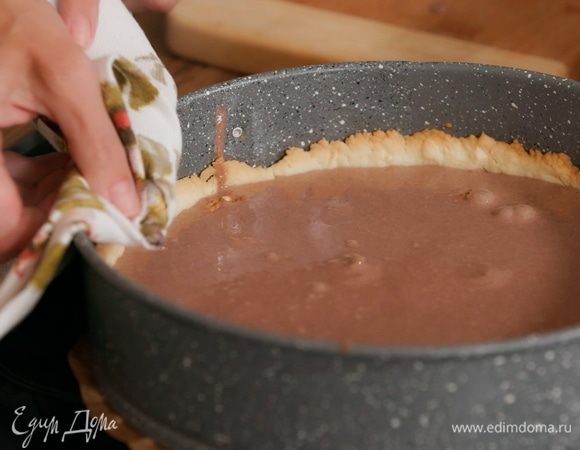 На подпеченный корж выложить половинки грецких орехов, влить взбитую сгущенку.