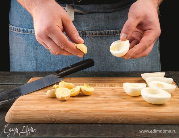 Яйца отварите вкрутую, очистите, разрежьте пополам и достаньте желтки.