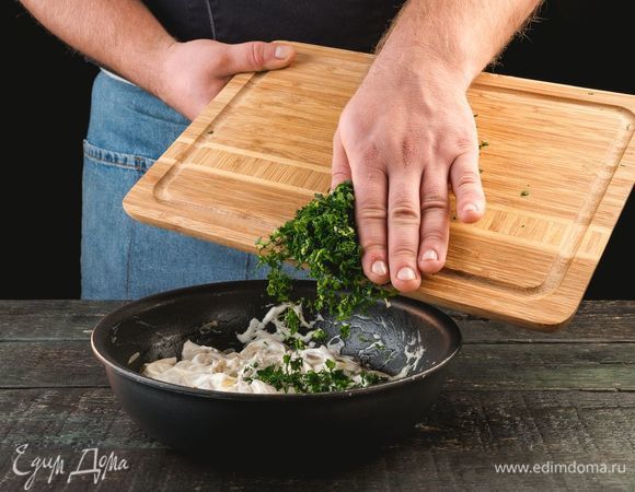 Добавьте сметану и нашинкованную зелень. Потомите на огне минуты две.