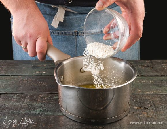 В сотейнике разогрейте сливочное масло, всыпьте муку. Обжарьте смесь в течение 4 минут.