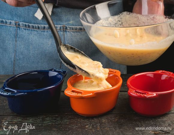 Формочки для запекания смажьте маслом, застелите пергаментом и выложите тесто с морепродуктами.