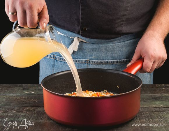 Небольшими порциями влейте 300 мл бульона, пока рис не впитает жидкость.