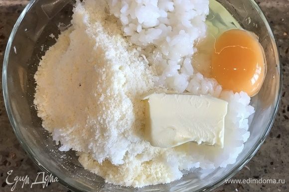 В миску с рисом добавляем куркуму, одно яйцо, размягченное сливочное масло. Хорошо перемешиваем все ингредиенты между собой, после добавляем сыр.