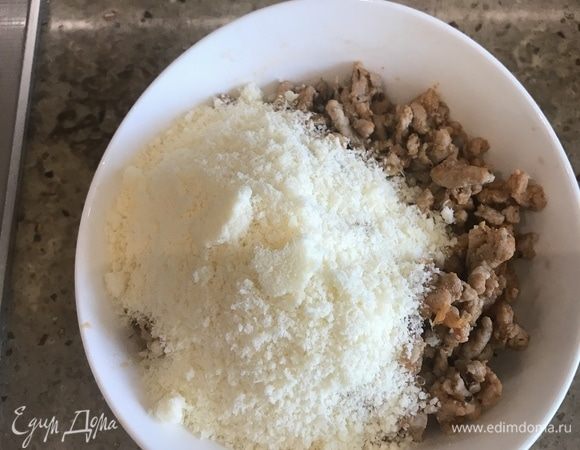 Готовую мясную начинку перекладываем в миску, остужаем до терпимой комнатной температуры, добавляем остатки сыра.