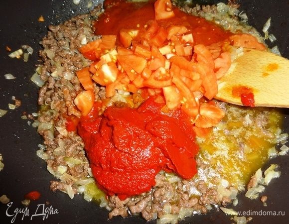 В сковороду к обжаренному с луком фаршу выложить томатную пасту, томатный соус из консервированных помидоров ТМ «Помидорка» и кусочки свежих помидоров, перемешать.