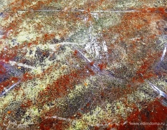 Рабочую поверхность накрываем пищевой пленкой и наносим на нее соль, перец и ваши любимые приправы для курицы.