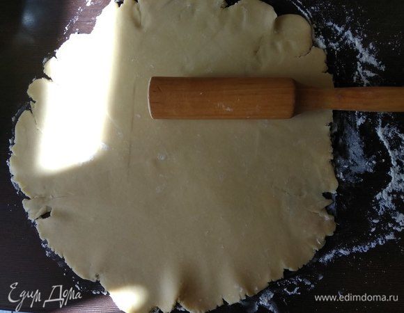 Разогреваем духовку до 180°C. Достаем тесто и на присыпанной мукой поверхности тонко раскатываем в круг.