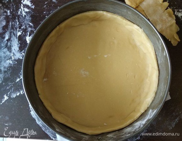 Разъемную форму (диаметр 21 см) смазываем сливочным маслом или выстилаем пергаментом. Тесто наматываем на скалку и выкладываем в форму, руками приминаем тесто по диаметру, делаем бортики высотой сантиметров 5 (можно больше, у нас сверху начинки будет еще релиш), ненужные торчащие края теста аккуратно обрезаем (если осталось много теста завернем его в пленку и отправим в холодильник до использования, оно прекрасно хранится). Накалываем тесто по всему диаметру вилкой и отправляем в разогретую духовку на 10 минут.