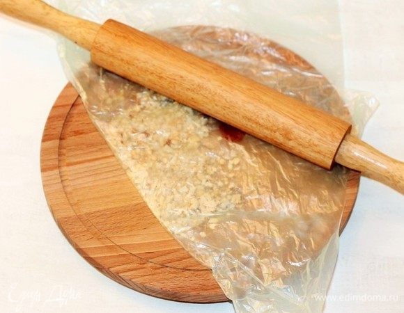Очищенные и обжаренные на сухой сковороде кедровые орехи измельчаем скалкой. Величина помола — на ваш вкус. Нет кедровых орешков — возьмите арахис или грецкие, с ними тоже вкусно.