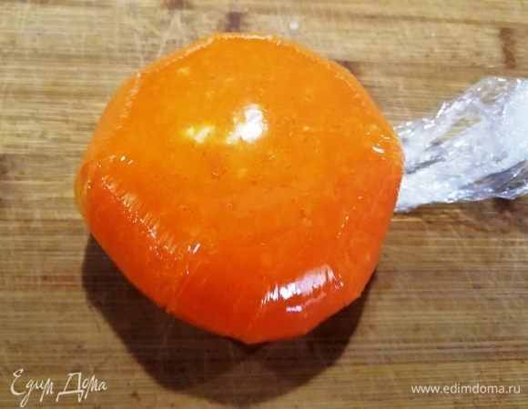 Поднимая пленку, оборачиваем морковкой шарики. Затягиваем края пленки и убираем заготовки в морозильную камеру на 15 минут.