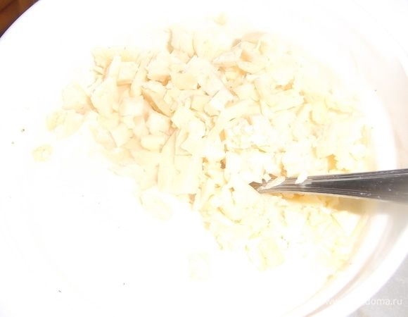 Яйца взболтать с оставшейся сметаной, солью и перцем. Добавить измельченный сыр. Перемешать.