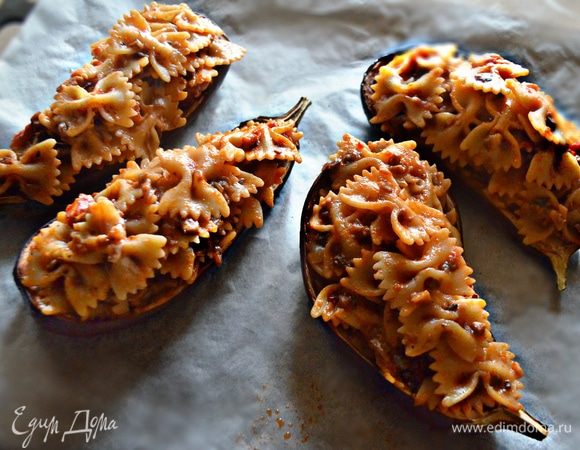 Подготовленные «лодочки» из баклажанов промойте в холодной воде, промокните бумажным полотенцем. Выложите пасту в «лодочки» из баклажанов горкой. Затем поместите баклажаны на смазанный оливковым маслом лист пергамента. Запекайте 10–15 минут в духовке при 180°C.