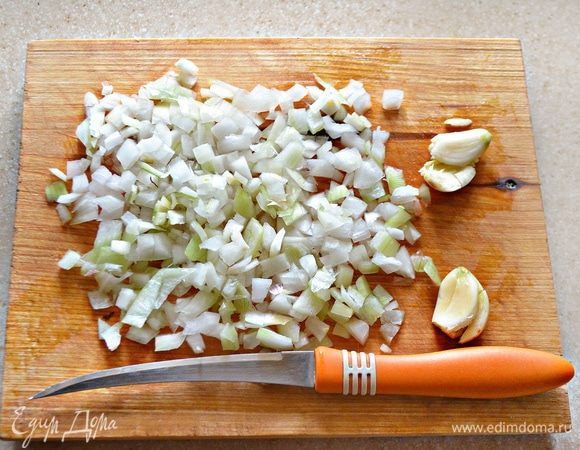 Лук мелко нарезать, зубчики чеснока слегка раздавить плоской стороной ножа.