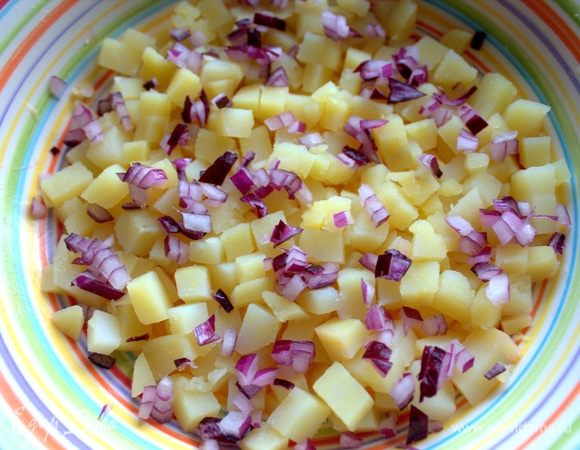 Насыпать на дно тарелки картошку и лук.