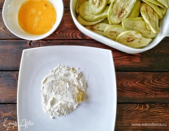Баклажаны сначала обмакиваем во взбитые яйца, даем стечь излишкам, а потом обваливаем в муке, стряхивая лишнюю, чтобы она не горела на сковороде.