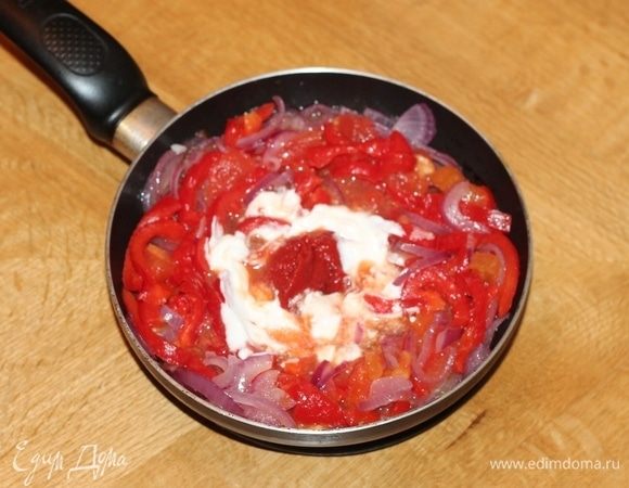 С помидоров снять кожицу. Для этого опустить их в кипяток на минуту и очистить кожицу. Нарезать помидоры дольками и добавить к овощам. Добавить к овощам 1 ст. л. сметаны, сливочное масло и томатный соус, посолить и поперчить, перемешать и тушить до готовности. Можно добавить щепотку сахара.