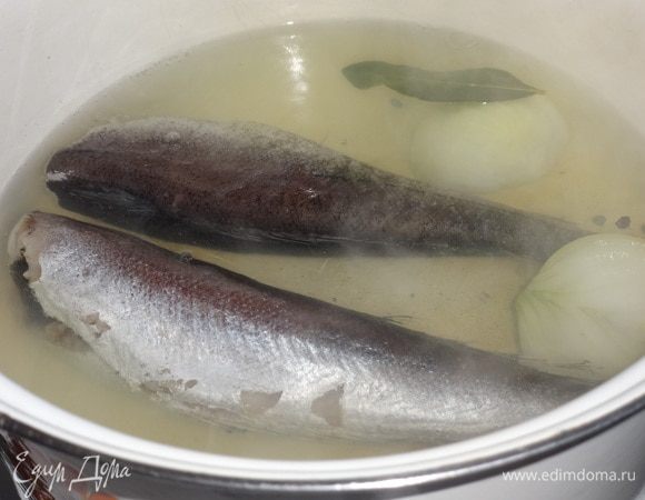 Лук почистить, вымыть, разрезать пополам. Воду вскипятить, положить в кастрюлю с водой рыбу, луковицу, лавровый лист, перец горошком. Довести до кипения, посолить. Огонь убавить и варить в течение 10 минут. Выключить огонь и дать рыбе остыть в бульоне.