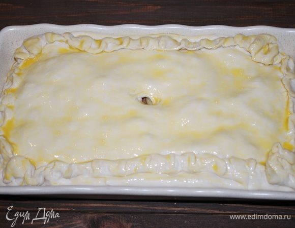 Начинку закроем «крышкой» из теста, защипнем края и смажем пирог яичным желтком, сделаем отверстие по середине. Выпекать при 180°C примерно 40 минут.