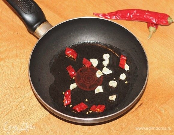 На разогретом растительном масле подрумянить очищенный нарезанный чеснок и острый перец чили. Овощи удалить, масло оставить.