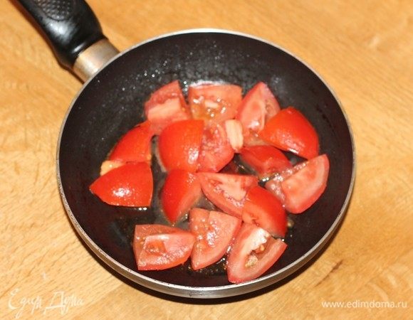 На чесночном масле обжарить нарезанные крупными дольками помидоры.