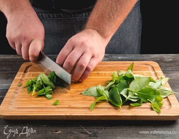Крупно нашинкуйте базилик.