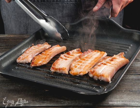 Хорошо разогрейте сковороду-гриль (или обычную сковороду с толстым дном) и обжарьте кусочки бекона до хрустящей золотистой корочки. Переверните их не менее четырех раз, чтобы лучше вытопить жир. Выложите жареный бекон на бумажное полотенце.