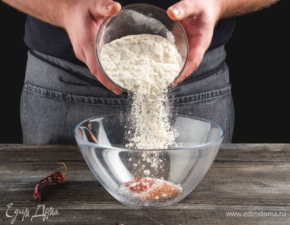 Промойте крылышки, обсушите бумажными полотенцами. В глубокой емкости смешайте муку, соль и все специи, кроме чеснока.