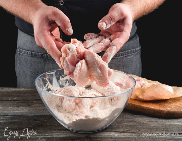 Запанируйте в муке со специями крылышки и оставьте на 20–30 минут.