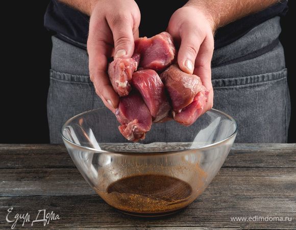 Свинину нарежьте крупными кубиками, посыпьте молотым имбирем, солью и крахмалом, полейте соевым соусом, перемешайте. Оставьте мясо мариноваться на полчаса.