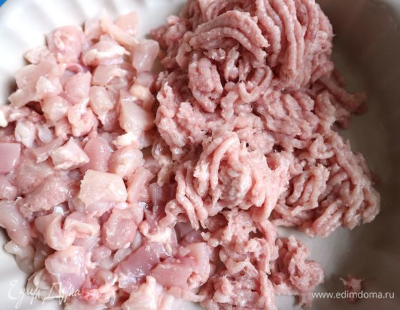 Большую часть филе куриных бедер (490 г) прокрутить через мясорубку, другую часть нарезать на мелкие кубики.