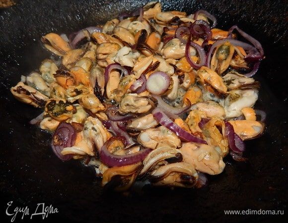 Лук слегка обжарить в небольшом количестве оливкового масла. Добавить мидии и обжаривать 3 минуты.