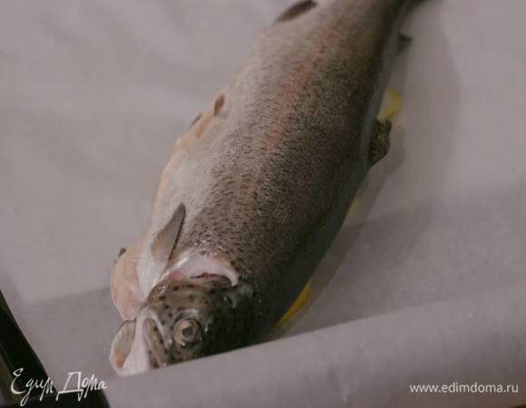 Противень застелить двумя листами бумаги для выпечки, на каждый уложить несколько кружков лимона и лайма, а сверху тушку форели.