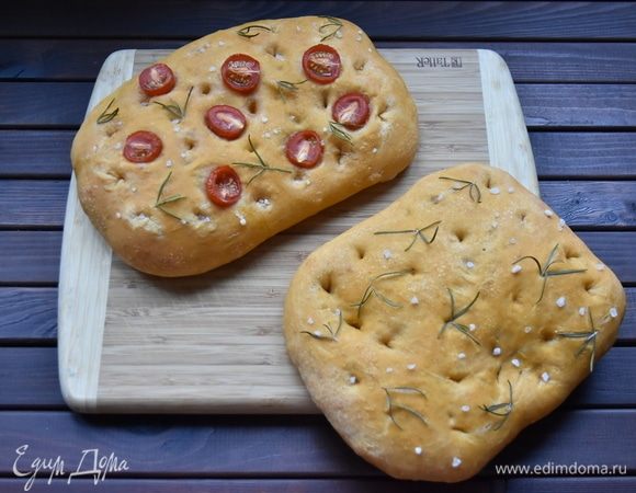 Духовку разогреть до 230°C вместе с противнем, на котором будет выпекаться хлеб. Аккуратно перенести заготовки вместе с бумагой на противень. Выпекать лепешки 13–15 минут. Остудить хлеб на решетке.