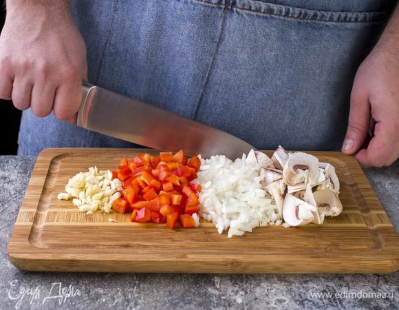 Разрежьте шампиньоны на несколько частей, лук и болгарский перец нарежьте мелкими кубиками, измельчите чеснок.