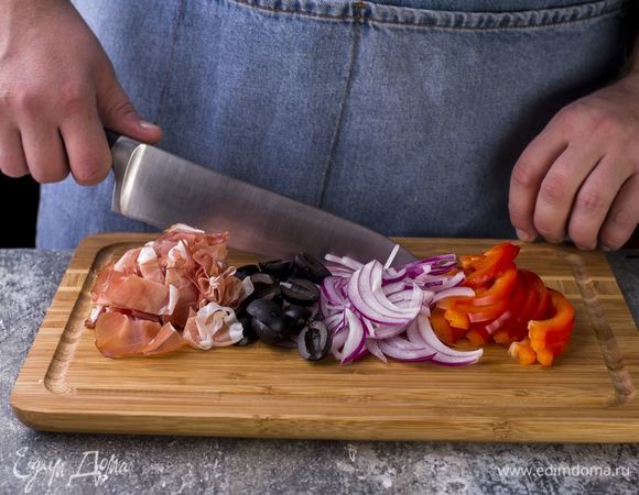 Перец очистите от семян, нарежьте соломкой. Красный лук нарежьте полукольцами, маслины разрежьте пополам, часть ветчины измельчите.