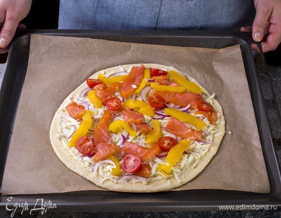 Раскатайте тесто в круглый пласт, смажьте небольшим количеством сливочного соуса, посыпьте тертой моцареллой. Сверху выложите начинку.