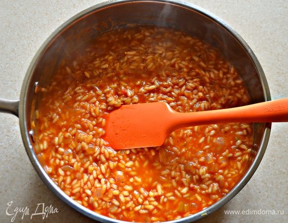 Затем влейте рыбный бульон, половину томатного соуса и готовьте на среднем огне, периодически помешивая, 15 минут. По мере выпаривания жидкости добавляйте оставшийся томатный соус.