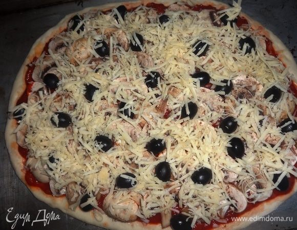 Посыпать поверхность пиццы сыром. Поставить противень с пиццей в разогретую до 190°C духовку на 20–25 минут.