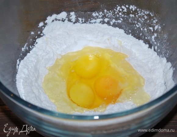 Сделаем домашнюю пасту. Муку соединим с солью, добавим яйца. Замесим пасту. Из этого количества муки и яиц получится примерно 450 г. Для наших равиоли мы возьмем половину готового теста.