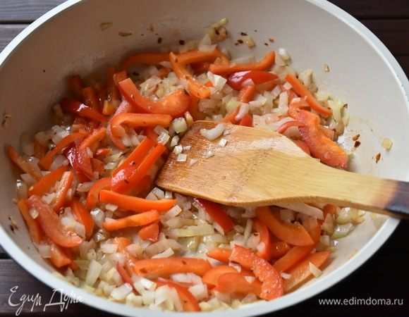 Когда чеснок и перец отдадут маслу аромат и вкус, выложить подготовленные болгарский перец и лук. Обжарить в течение 3–4 минут.