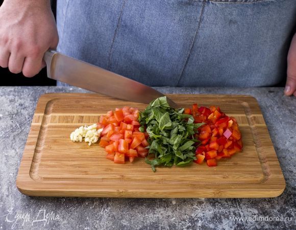 У помидоров удалите семена и лишнюю жидкость. Перец и помидоры нарежьте мелким кубиком. Чеснок и базилик измельчите.