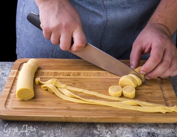 Раскатайте тесто в тонкий пласт. Скрутите его в рулет, нарежьте колечками толщиной примерно 0,5 см. Развернув колечки, вы получите традиционную домашнюю лапшу.