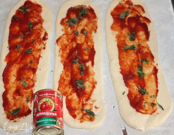Готовое тесто разделить на 3 части и раскатать 3 полоски. Смазать каждую томатной пастой ТМ «Помидорка», посыпать базиликом.