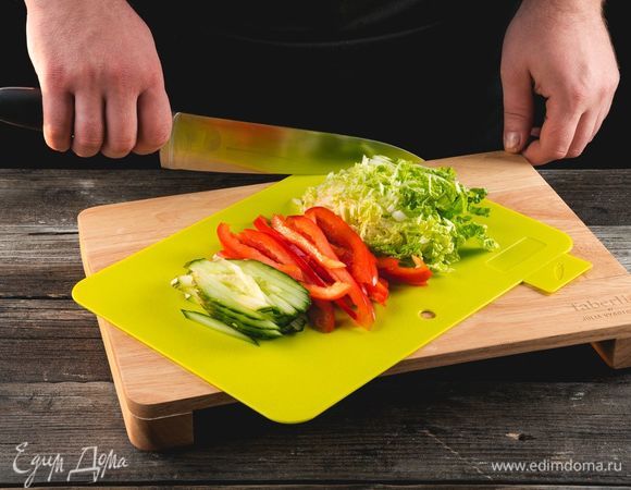 Нарежьте тонкой длинной соломкой огурец, сладкий перец, пекинскую капусту, используя разделочную доску Faberlic by Julia Vysotskaya.