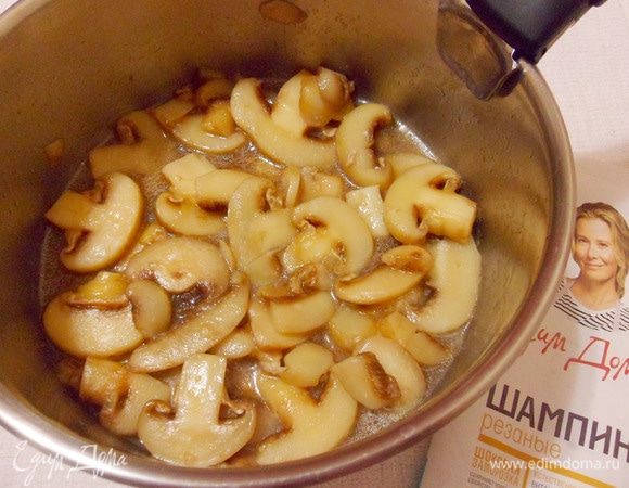 Добавить в сотейник сливочное масло, выложить замороженные шампиньоны, перемешать, готовить на сильном огне до полного выпаривания жидкости из грибов.