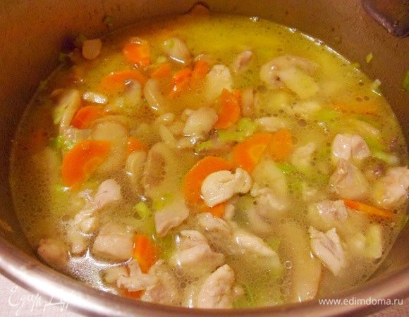 Затем вернуть в сотейник обжаренное куриное филе, добавить щепотку сушеного тимьяна и влить куриный бульон. Довести до кипения и варить под крышкой на медленном огне около 15–20 минут.