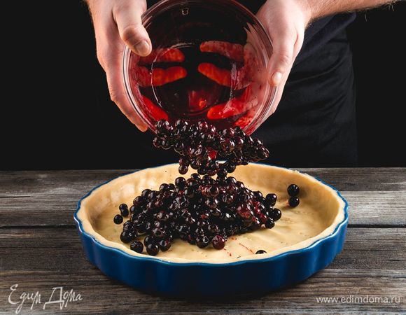 Высыпьте в форму промытые ягоды черной смородины.