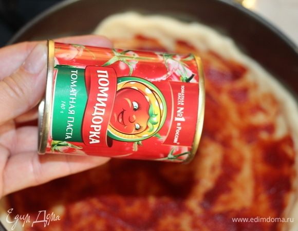 Готовое тесто разделить на 2 части. Первую часть раскатать и выложить в форму, формируя бортики. Смазать 1ст. л. томатной пасты ТМ «Помидорка».