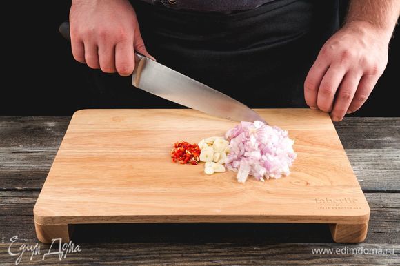 Мелко нарежьте луковицу, чили, чеснок. Используйте для этого разделочную доску Faberlic by Julia Vysotskaya.