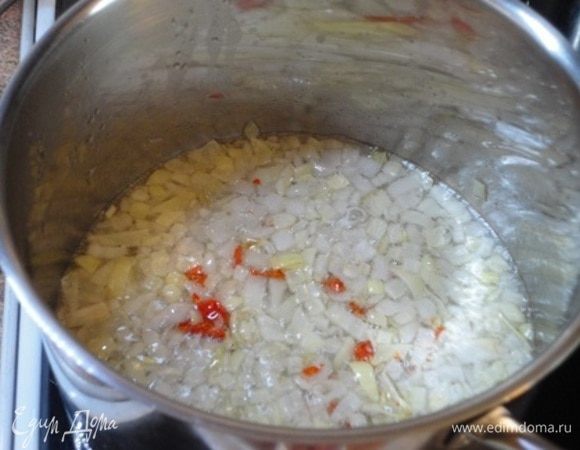 Лук нарезать мелкими кубиками. 3 ст. л. оливкового масла разогреть в кастрюле с толстым дном. Лук потомить при небольшом нагреве, не допуская зажаривания, добавить перец чили хлопьями и продолжать томить, периодически помешивая. В итоге лук закарамелизируется и станет золотым, как для лукового супа.
